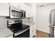 Updated kitchen with black range and stainless steel microwave at 1197 Stillwood Ct, Port Orange, FL 32129