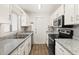 Galley kitchen with white cabinets and granite counters at 1197 Stillwood Ct, Port Orange, FL 32129