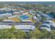 This aerial view showcases a charming community with well-maintained buildings, tennis courts, and a serene lake at 140 Limewood Pl # 2, Ormond Beach, FL 32174