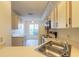 Open kitchen featuring white cabinets and appliances with a garden view beyond at 140 Limewood Pl # 2, Ormond Beach, FL 32174