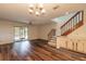 Bright living room featuring wood floors, a ceiling fan, sliding glass doors, and wooden staircase at 140 Limewood Pl # 2, Ormond Beach, FL 32174