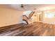 Open-concept living room boasting wood floors, a ceiling fan, access to the staircase, and a bright and airy atmosphere at 140 Limewood Pl # 2, Ormond Beach, FL 32174