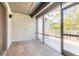 Enclosed carpeted patio with door leading to an outdoor deck and views of mature trees at 140 Limewood Pl # 2, Ormond Beach, FL 32174