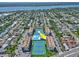 Scenic aerial view of a condo community featuring tennis courts, a sparkling pool, and lush landscaping, all with a beautiful waterfront view at 1441 N Atlantic Ave # 211, Daytona Beach, FL 32118