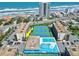 Aerial view of beachfront condo complex featuring a swimming pool, tennis courts, and ocean views at 1441 N Atlantic Ave # 211, Daytona Beach, FL 32118