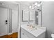 Bathroom features a vanity with white cabinetry, a large mirror, and updated lighting fixtures at 1441 N Atlantic Ave # 211, Daytona Beach, FL 32118