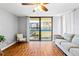 Open living room features wood floors, fan, natural light from the glass doors to the balcony and modern decor at 1441 N Atlantic Ave # 211, Daytona Beach, FL 32118