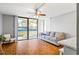 Bright living room with wood floors, sofa, and sliding doors to balcony at 1441 N Atlantic Ave # 211, Daytona Beach, FL 32118