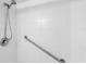 Shower with a grab bar offers safety and accessibility, complemented by tiled walls for easy maintenance at 1441 N Atlantic Ave # 211, Daytona Beach, FL 32118