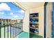 Balcony storage with door ajar view of tennis courts, road, buildings and blue skies at 1441 N Atlantic Ave # 417, Daytona Beach, FL 32118