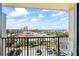 Balcony view of the road, parking, buildings and ocean with palm trees and clouds at 1441 N Atlantic Ave # 417, Daytona Beach, FL 32118