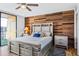 Stylish bedroom with wood accent wall, gray furnishings, and a balcony at 1441 N Atlantic Ave # 417, Daytona Beach, FL 32118