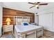 This cozy bedroom features a rustic wood accent wall and a comfortable bed with plush pillows at 1441 N Atlantic Ave # 417, Daytona Beach, FL 32118