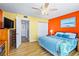 Bright bedroom with a colorful decor featuring a bed with blue accents and yellow and orange painted walls at 1441 N Atlantic Ave # 417, Daytona Beach, FL 32118