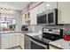 Bright kitchen with white cabinets, stainless appliances, and a tile backsplash with access to dining area at 1441 N Atlantic Ave # 417, Daytona Beach, FL 32118