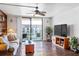 Cozy living room with wood accent wall, ceiling fan, and sliding glass doors to a balcony at 1441 N Atlantic Ave # 417, Daytona Beach, FL 32118