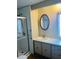 Bathroom featuring a walk-in shower and an oval mirror above the sink at 212 Rue De Pont, Tavares, FL 32778