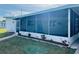 Exterior of a home with a screened-in lanai, manicured landscaping, and a view of the surrounding community at 212 Rue De Pont, Tavares, FL 32778