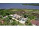 Waterfront home with a dock, screened-in pool, and detached garage surrounded by mature trees at 2189 Old Dixie Hwy, Ormond Beach, FL 32174