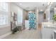 Bright bathroom with double shuttered windows, granite counters, accessible walk-in shower, and tiled floor at 2189 Old Dixie Hwy, Ormond Beach, FL 32174