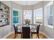 Cozy dining area with a glass table, leather chairs, natural light, and backyard views at 2189 Old Dixie Hwy, Ormond Beach, FL 32174