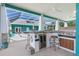 Outdoor kitchen with built-in grill, mini fridge, and seating at 2189 Old Dixie Hwy, Ormond Beach, FL 32174