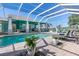 Screened in pool with brick patio, lounge furniture, and grilling area at 2189 Old Dixie Hwy, Ormond Beach, FL 32174