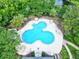 Aerial view of a unique pool area with lounge chairs and umbrellas surrounded by lush trees at 27 Winding Creek Way, Ormond Beach, FL 32174