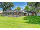 Expansive backyard featuring a screened-in pool area and lush green lawn at 27 Winding Creek Way, Ormond Beach, FL 32174