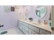 Well-lit bathroom featuring double sinks, white cabinets, and modern fixtures at 27 Winding Creek Way, Ormond Beach, FL 32174