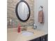Powder room featuring round mirror, stone backsplash, and modern fixtures at 27 Winding Creek Way, Ormond Beach, FL 32174