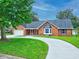 Brick house on large lot showing inviting circular drive and covered porch entry at 27 Winding Creek Way, Ormond Beach, FL 32174