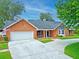 Charming brick home with a well-manicured lawn, circular driveway, and inviting porch at 27 Winding Creek Way, Ormond Beach, FL 32174