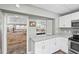 Bright kitchen offers white cabinets, stainless steel appliances, and an open pass-through to the main room at 27 Winding Creek Way, Ormond Beach, FL 32174