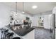 Well-lit kitchen featuring a breakfast bar with black countertops, white cabinets, and a skylight at 27 Winding Creek Way, Ormond Beach, FL 32174