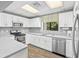 Updated kitchen featuring white cabinetry, stainless steel appliances, and a window overlooking the lush greenery at 27 Winding Creek Way, Ormond Beach, FL 32174