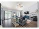 Comfortable living room with wood floors, backyard access, gray sofas and a vaulted ceiling at 27 Winding Creek Way, Ormond Beach, FL 32174