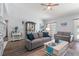 Well-decorated living room with gray sofas, wood floors, backyard access, and a stone fireplace at 27 Winding Creek Way, Ormond Beach, FL 32174