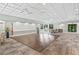 Open meeting room concept with wooden dance floor, coffered ceilings, large windows, and views of the outdoors at 27 Winding Creek Way, Ormond Beach, FL 32174