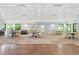 Inviting meeting room with several tables, chairs, wooden floors, and lovely views of the outdoors at 27 Winding Creek Way, Ormond Beach, FL 32174