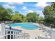 Community pool featuring a unique design with seating areas and mature trees at 27 Winding Creek Way, Ormond Beach, FL 32174