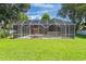 Backyard view of the pool enclosure with an inviting outdoor living space at 27 Winding Creek Way, Ormond Beach, FL 32174