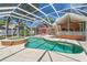 Inviting screened-in pool and spa area with outdoor dining and a brick home backdrop at 27 Winding Creek Way, Ormond Beach, FL 32174