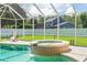 Sparkling screened-in pool with a spa, surrounded by lush landscaping and a well-maintained lawn, perfect for relaxation at 27 Winding Creek Way, Ormond Beach, FL 32174