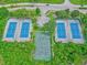 Aerial showcasing the community's amenities, featuring tennis and basketball courts amidst lush greenery at 27 Winding Creek Way, Ormond Beach, FL 32174