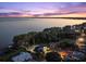 Stunning aerial view of the lakefront home at dusk, showcasing the home's proximity to the water and neighborhood at 3130 Indian Trl, Eustis, FL 32726