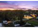 Scenic aerial view of the waterfront home, dock, and lush surrounding landscape during twilight at 3130 Indian Trl, Eustis, FL 32726