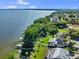 Waterfront property featuring lush landscaping, a private dock, and screened lanai at 3130 Indian Trl, Eustis, FL 32726