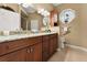 Bathroom features a double sink with granite counters, wood cabinets, and a decorative window at 3130 Indian Trl, Eustis, FL 32726