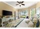 Well-lit bedroom featuring a decorative ceiling fan, a TV, and large windows with a backyard view at 3130 Indian Trl, Eustis, FL 32726